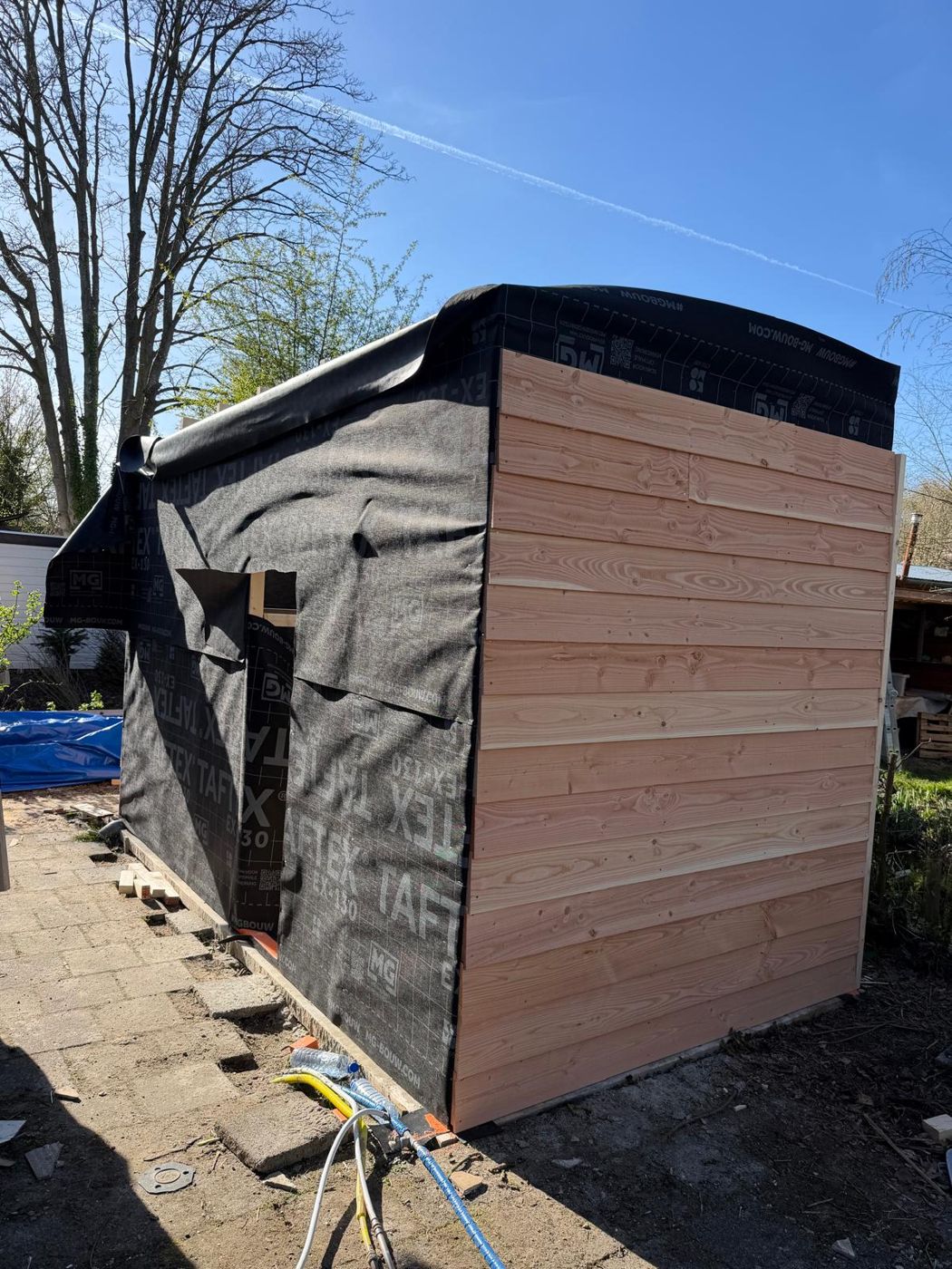 Houten gevelbekleding wordt aangebracht
